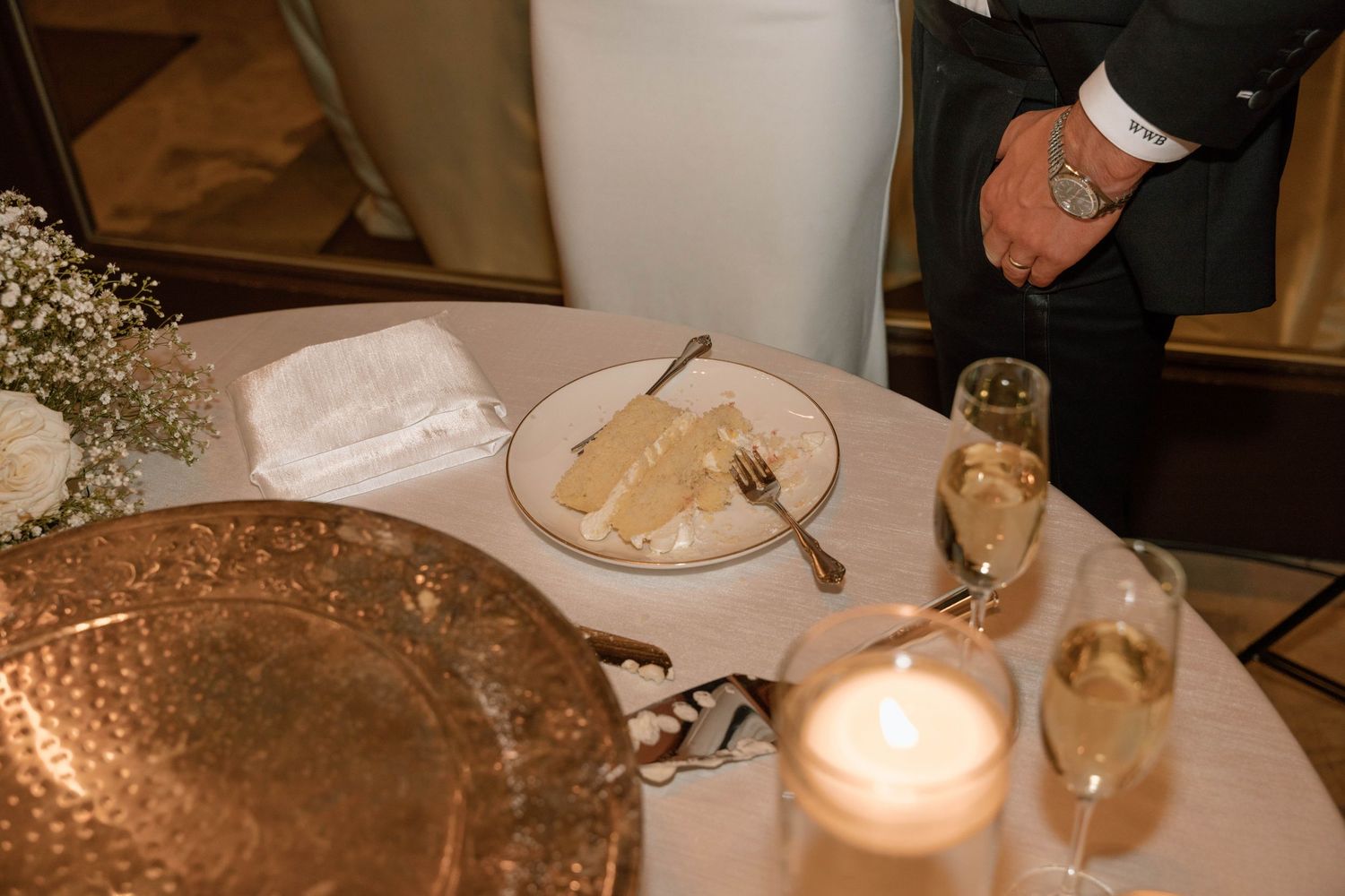 Elegant table settings with candlelight and white linens at a formal event.