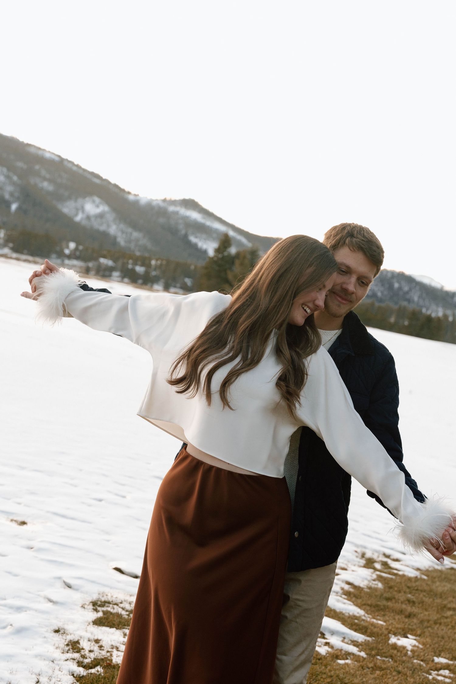 Candid moments captured during a winter couples photoshoot by a lake.