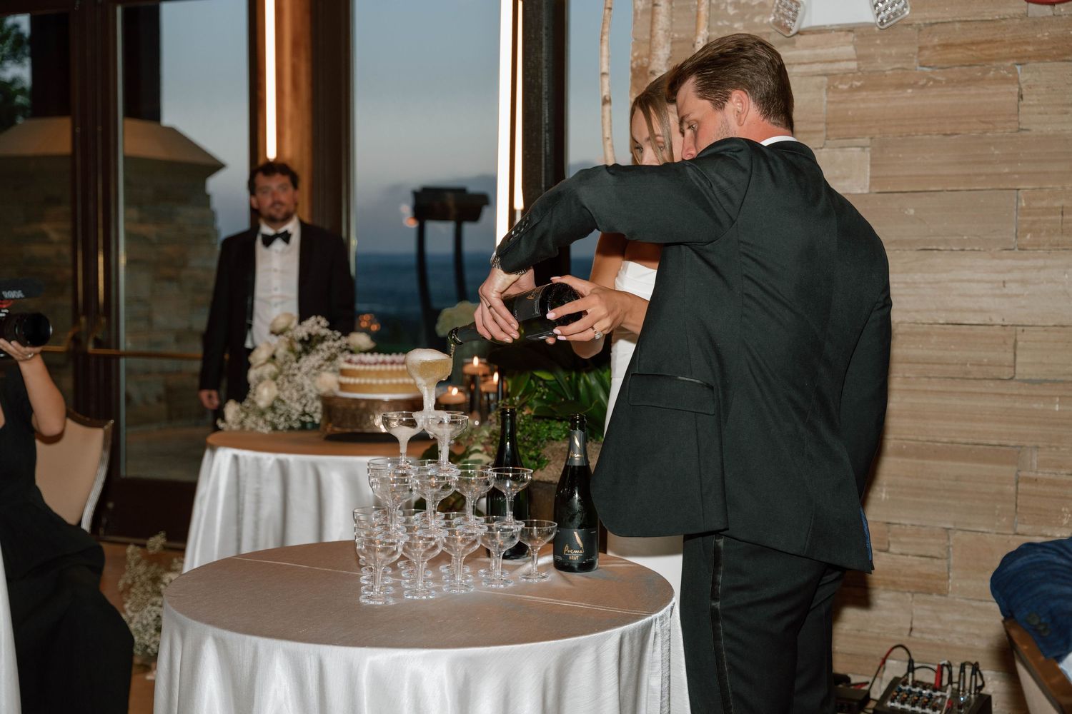 Wedding reception guests mingling around cocktail tables with drinks and appetizers.