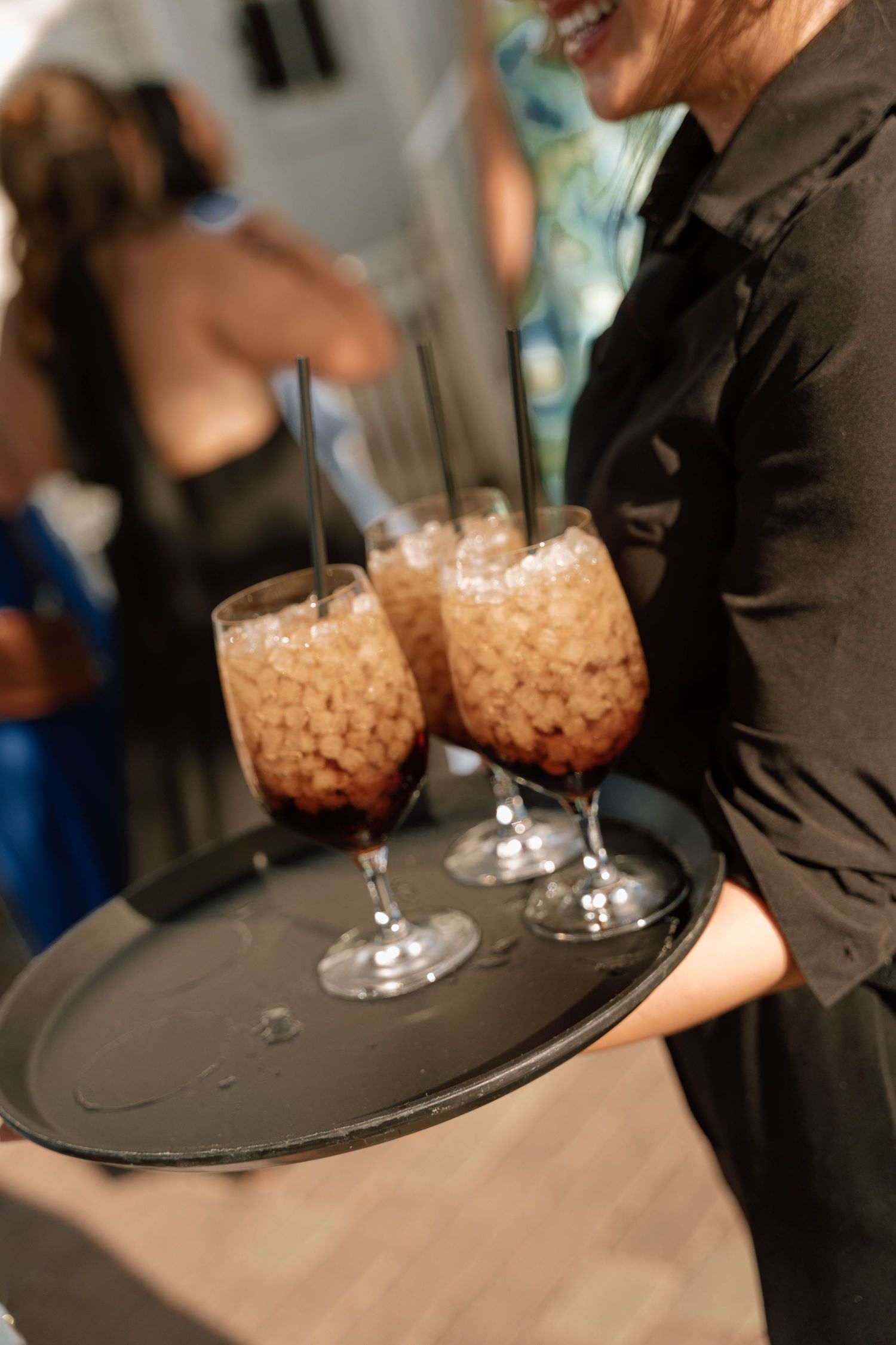Server carries appetizers on a black tray during an elegant event.
