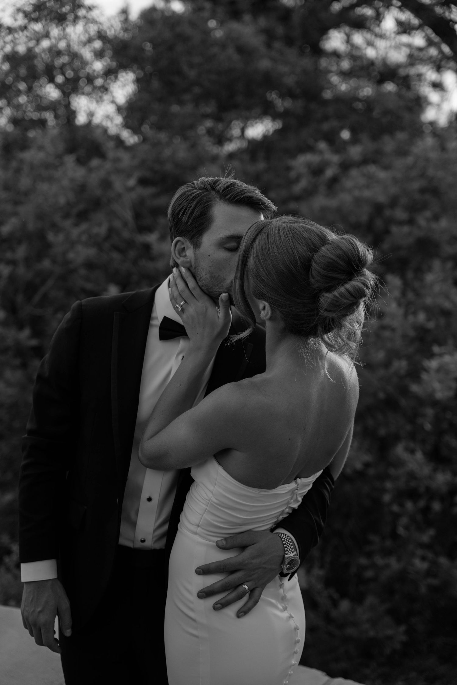 A tender moment between newlyweds sharing an intimate embrace outdoors.