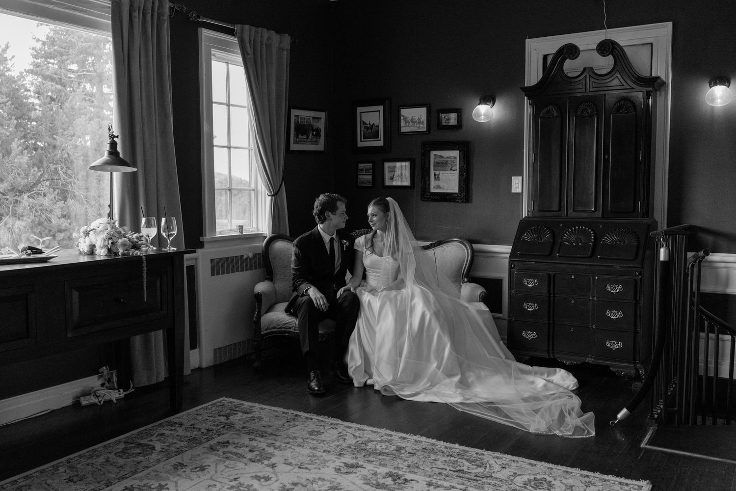 Wedding couple embraces in a dimly lit indoor venue with vintage decor and warm lighting.