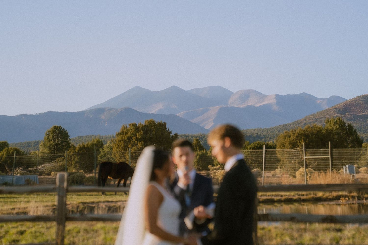 Scenic mountain landscape serves as backdrop for outdoor wedding ceremony.