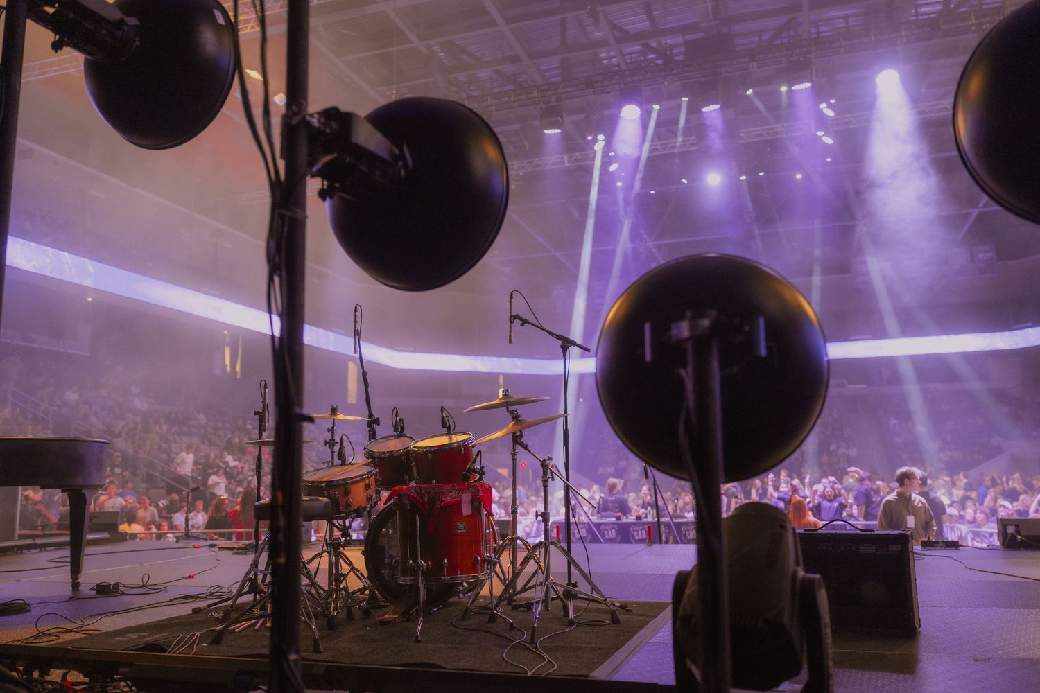 A purple-lit indoor event space with black balloons and decorative elements arranged for a celebration.