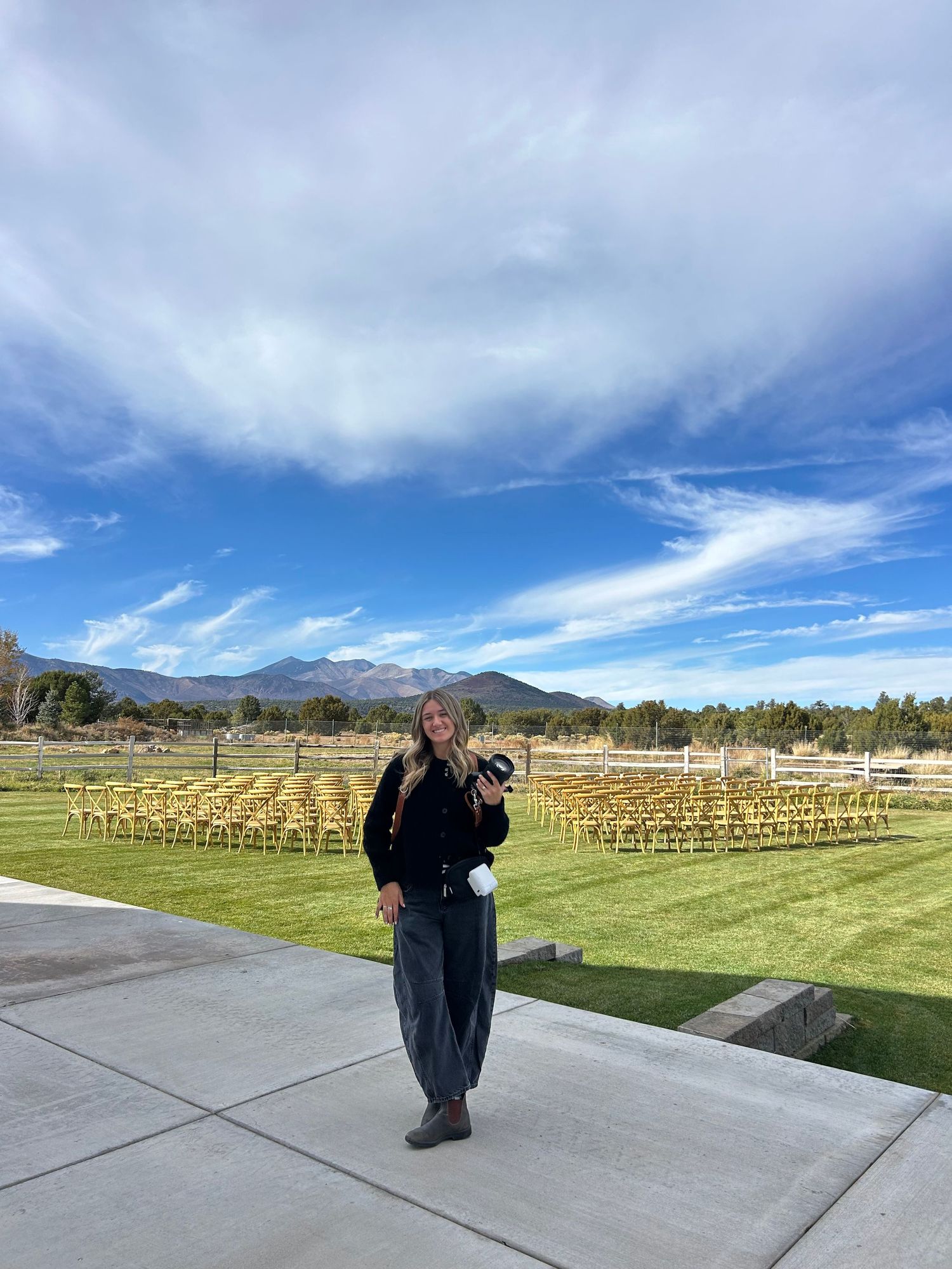 A panoramic sequence showing rows of wooden chairs set up outdoors with mountain views and dramatic cloudy skies.
