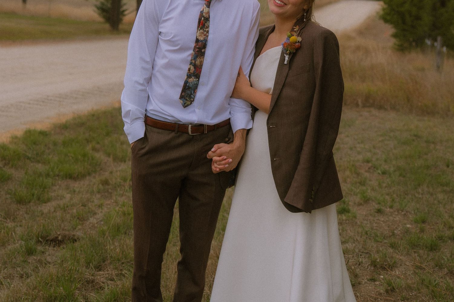 A couple shares an intimate moment outdoors during their rustic countryside wedding celebration.