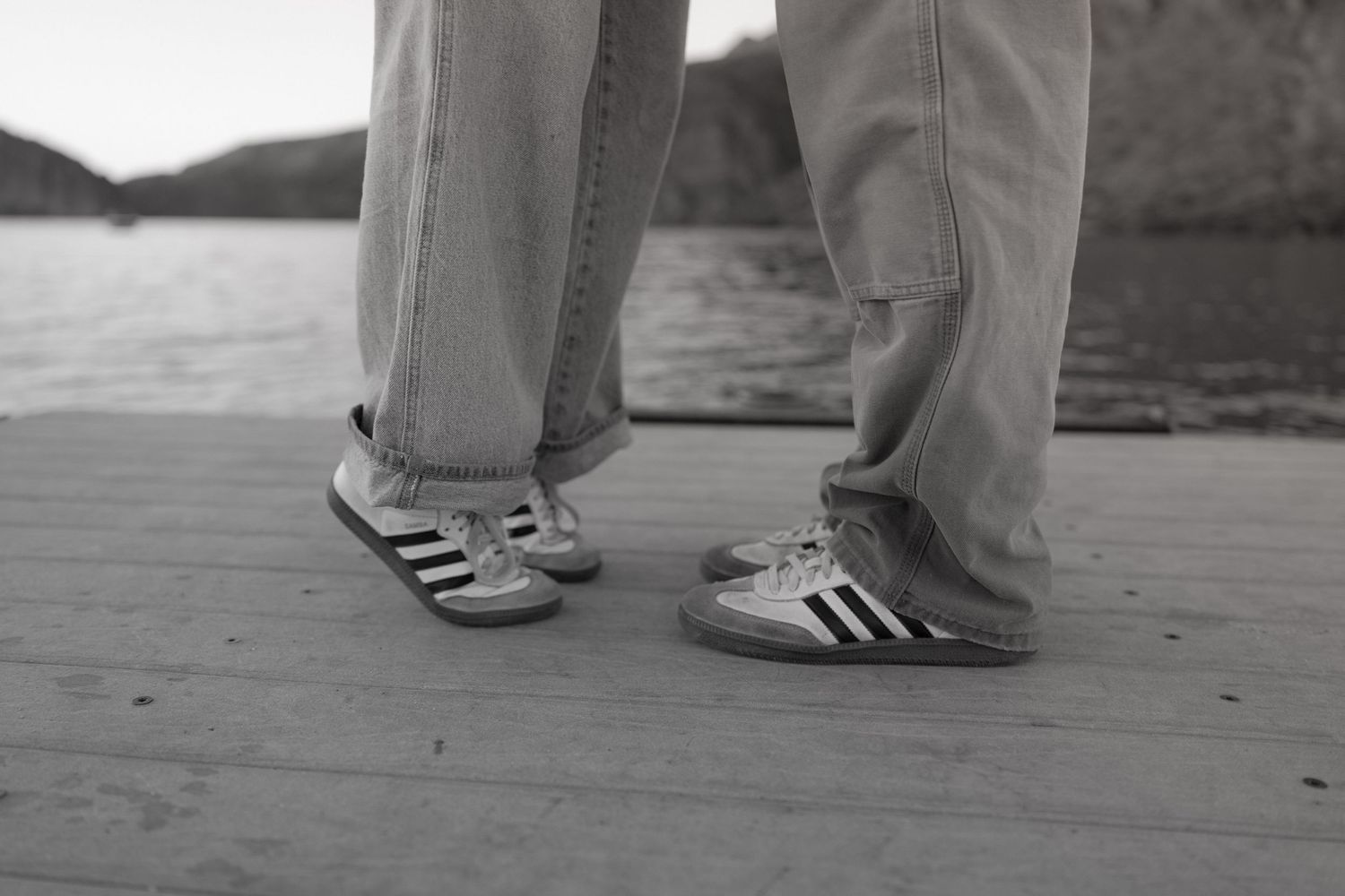 Close-up view of feet dancing in black and white shoes on a wooden dance floor.