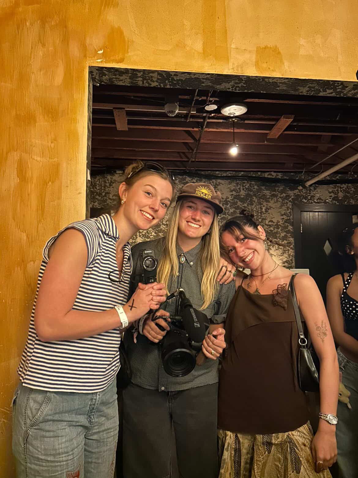 A group of friends in striped shirts and casual wear pose together for a series of fun photos at a dimly lit venue.