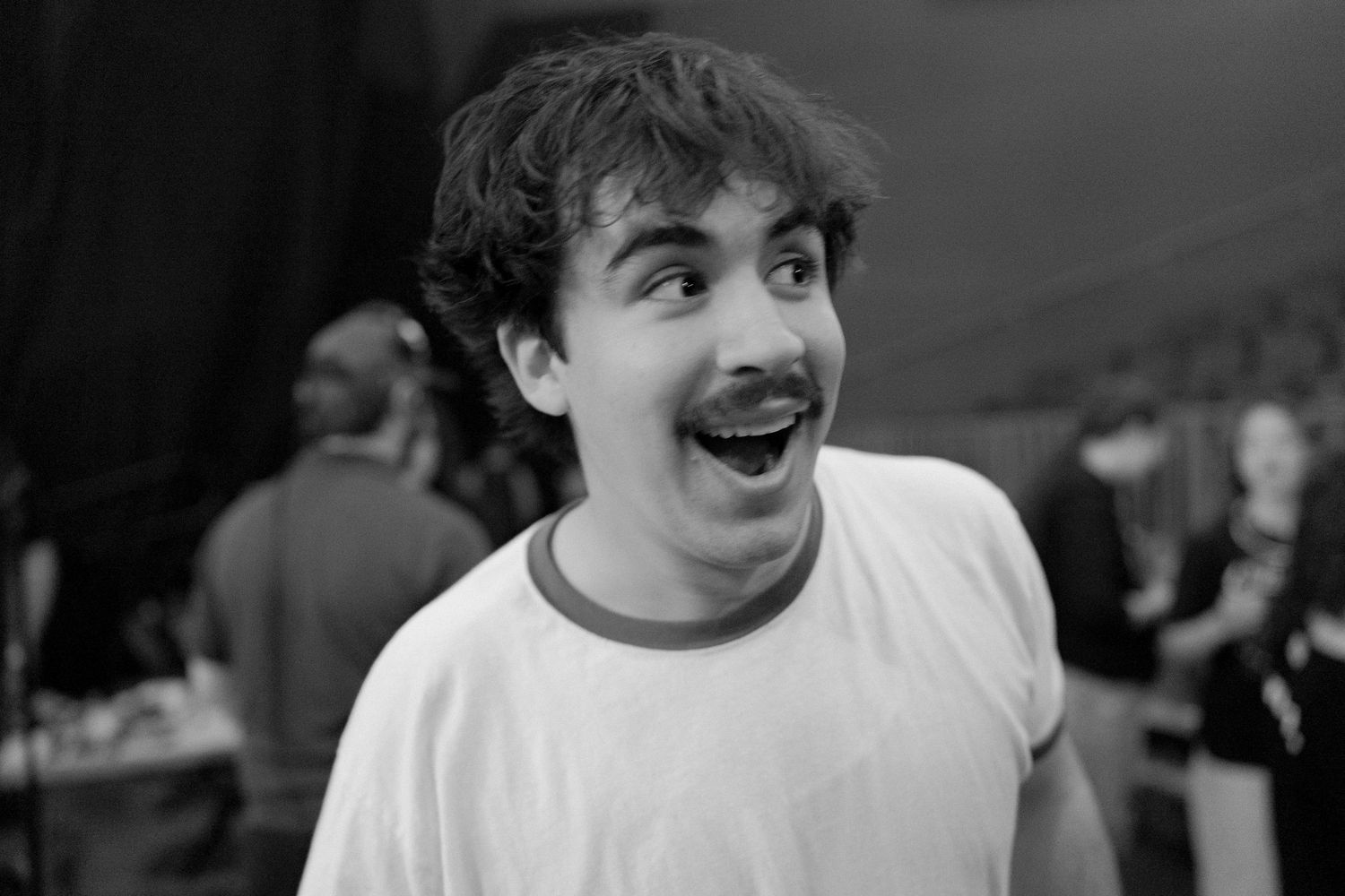 A series of black and white photos showing candid expressions and smiles in a casual setting.