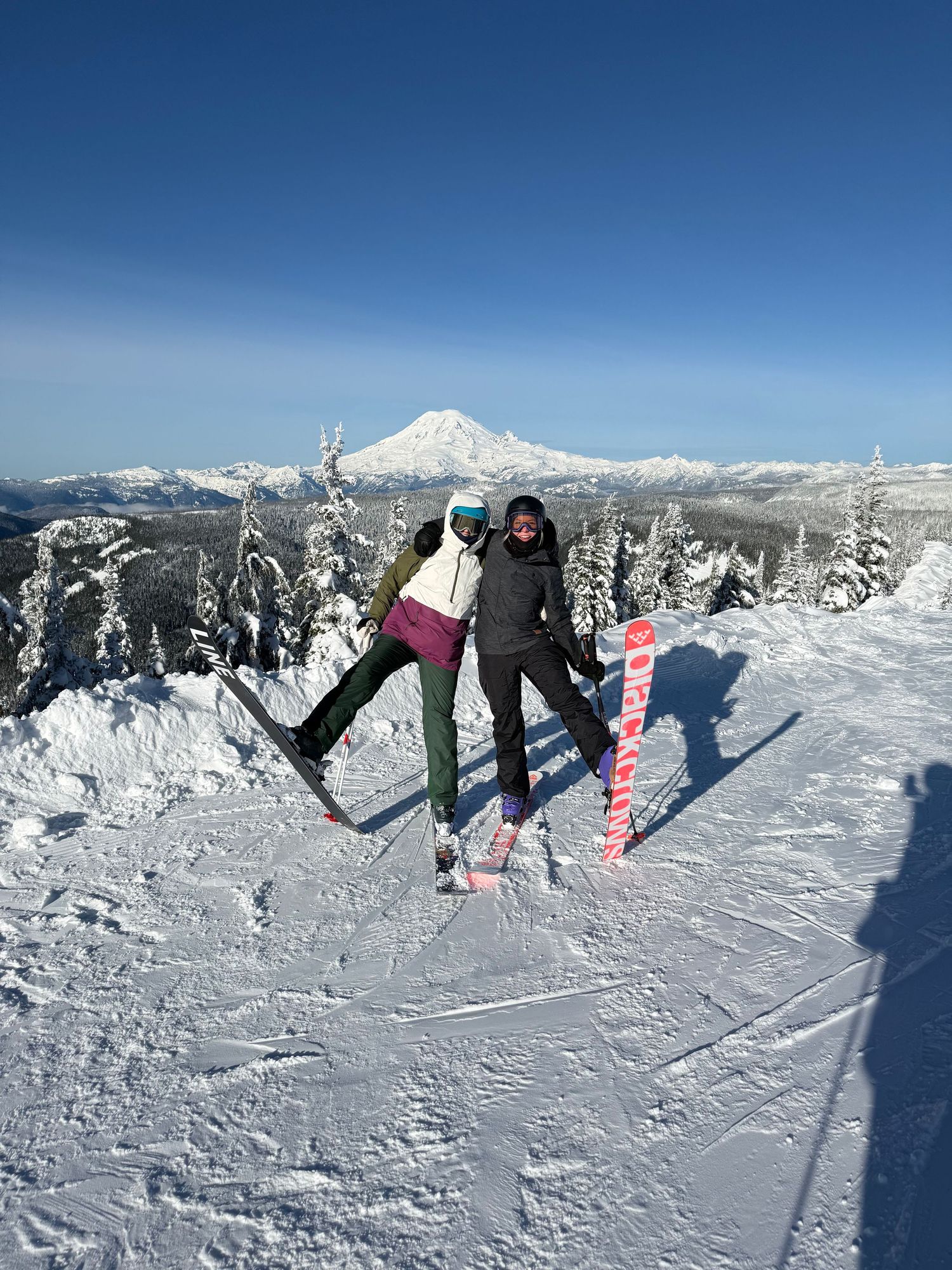 A sequence of snowboarding backflip trick progression shots against a snowy mountain backdrop and blue sky.