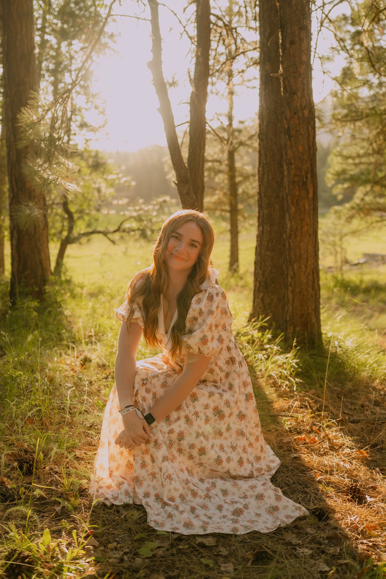 A dreamy forest scene with sunlit trees and a floral dress in golden afternoon light.