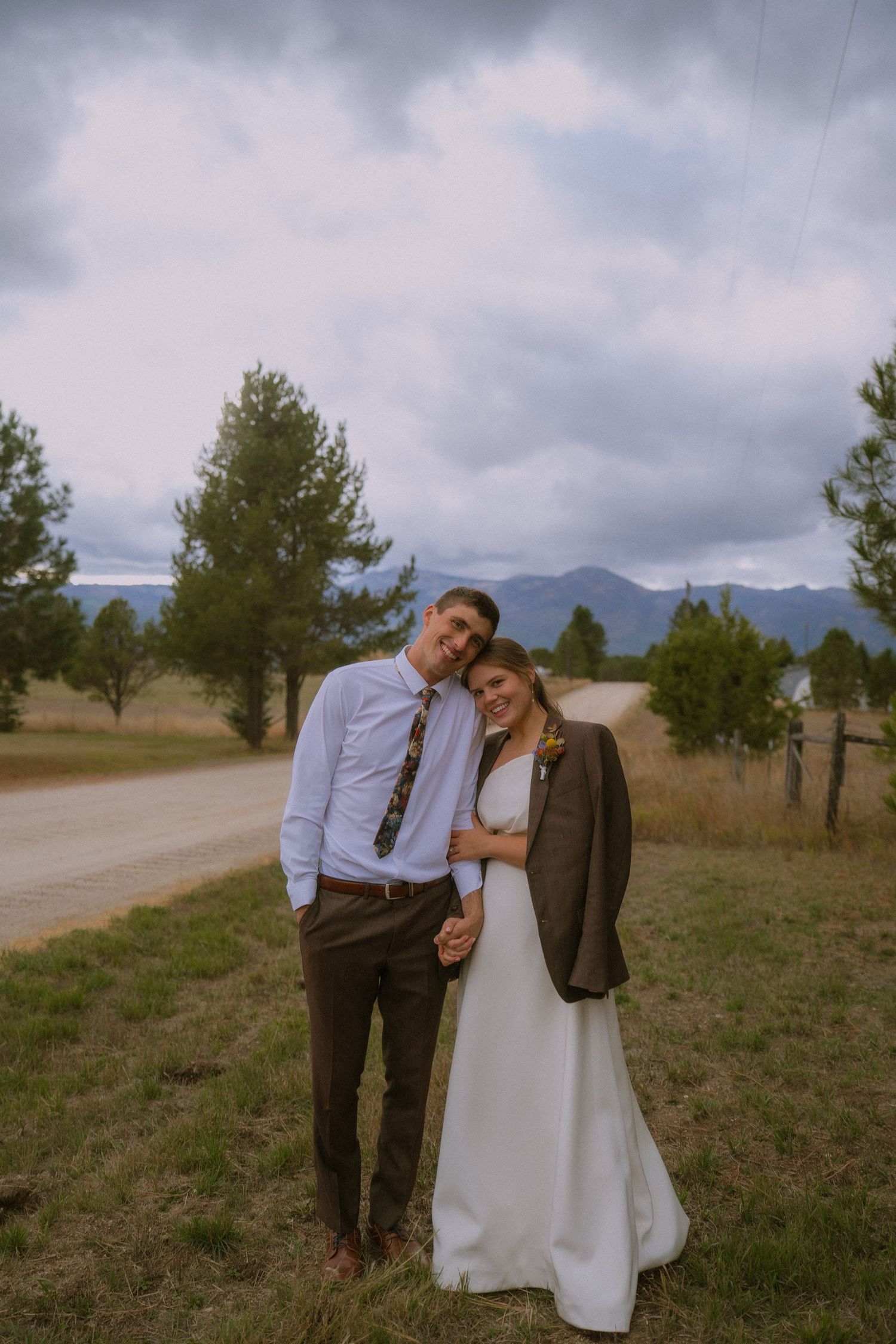 A couple shares a joyful moment on a cloudy day in the mountains.