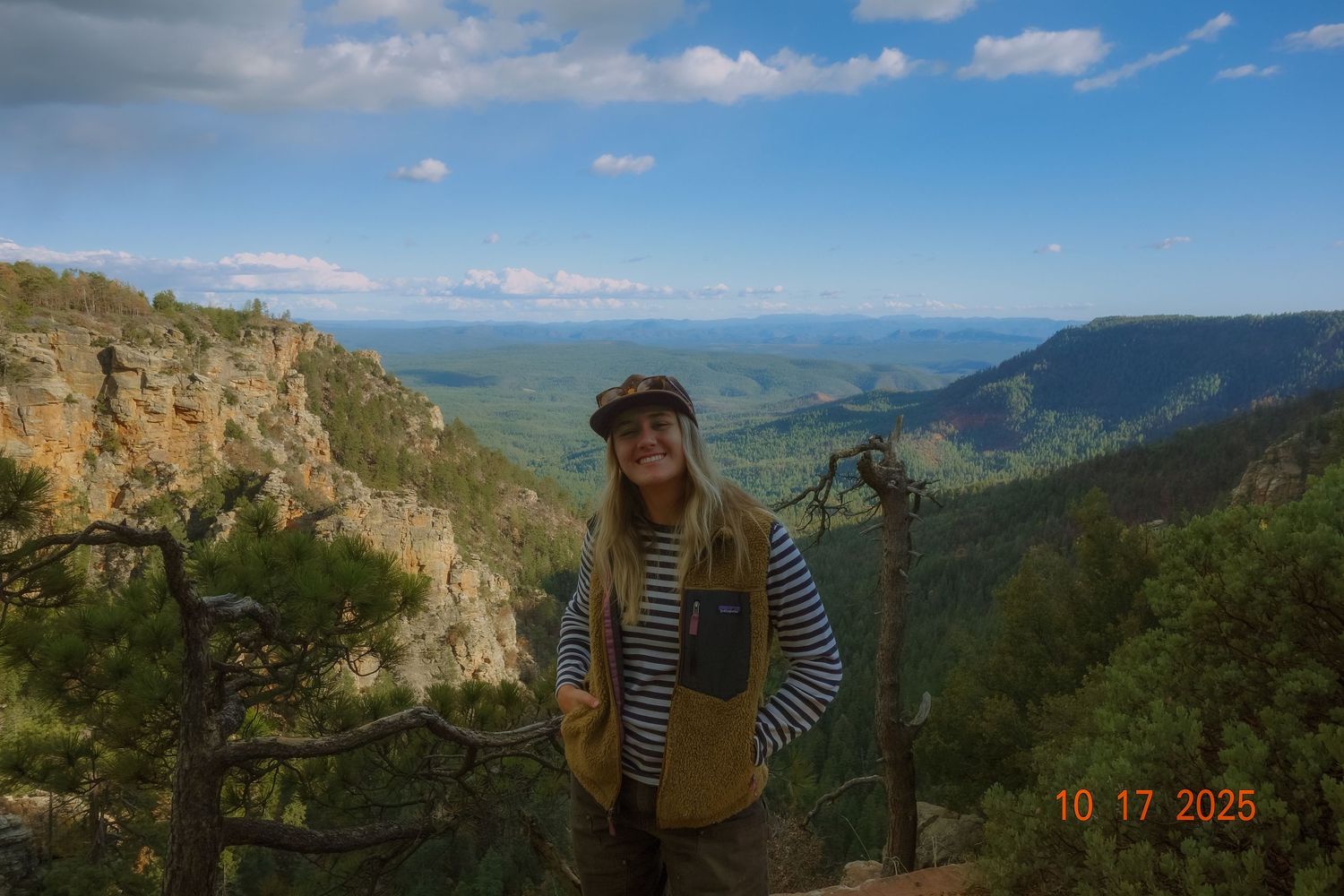 Scenic mountain landscape views from a hiking trail with rocky cliffs and green valleys stretching to the horizon.