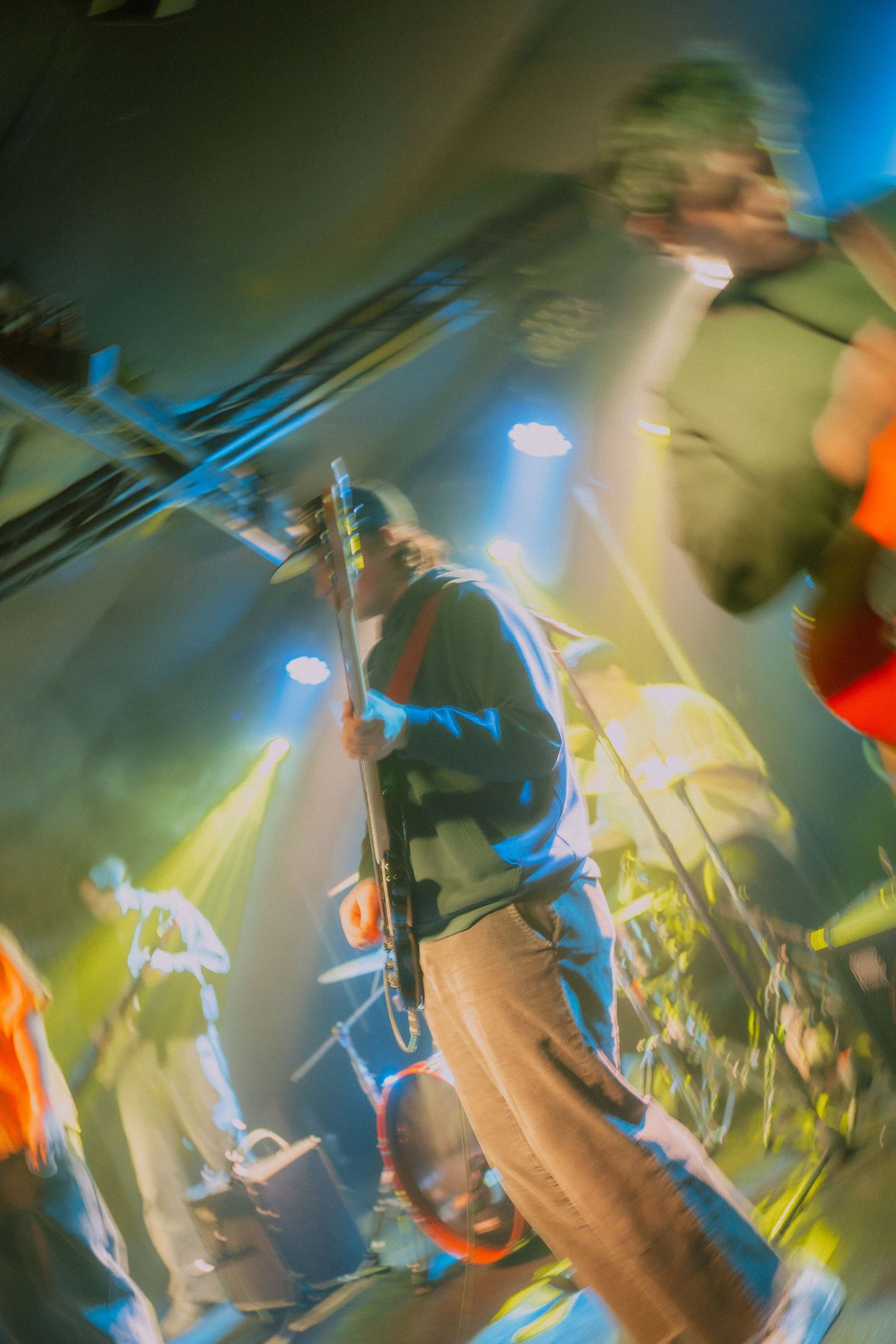 Abstract blurred motion photograph with swirling blue, green and orange colors creating a dynamic ethereal effect.