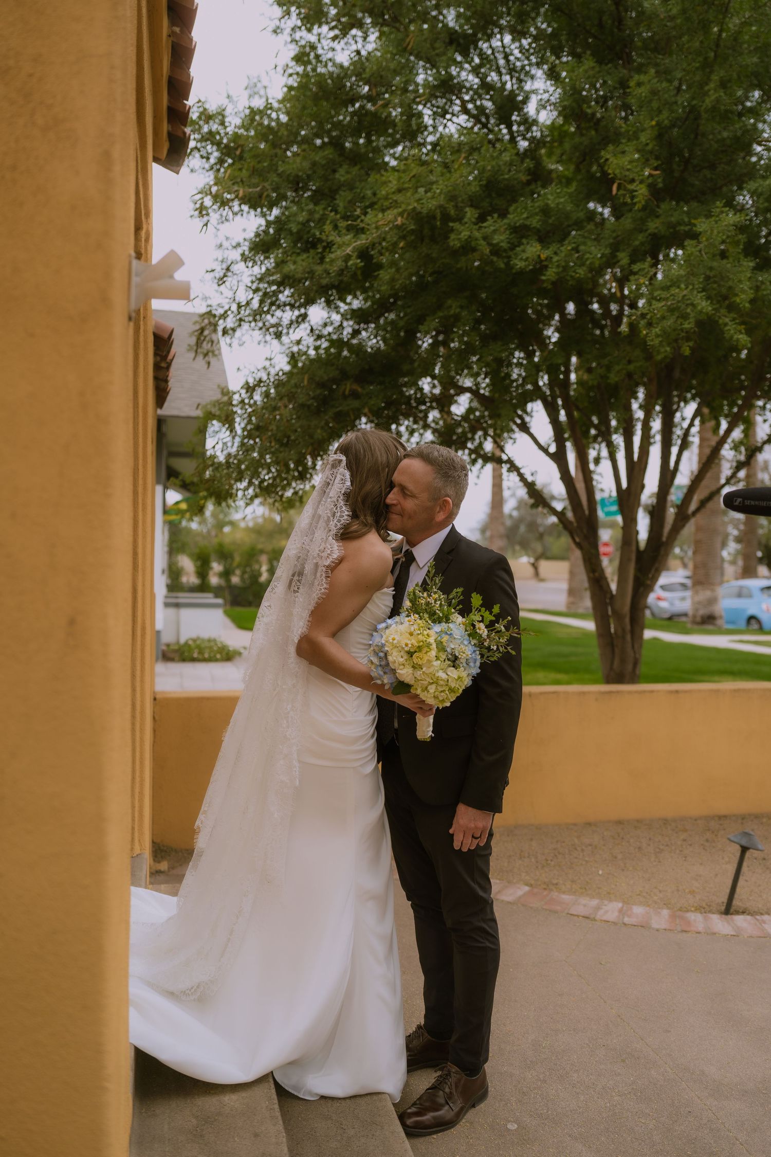 A series of romantic wedding photos showing tender moments between newlyweds against a yellow stucco building exterior.