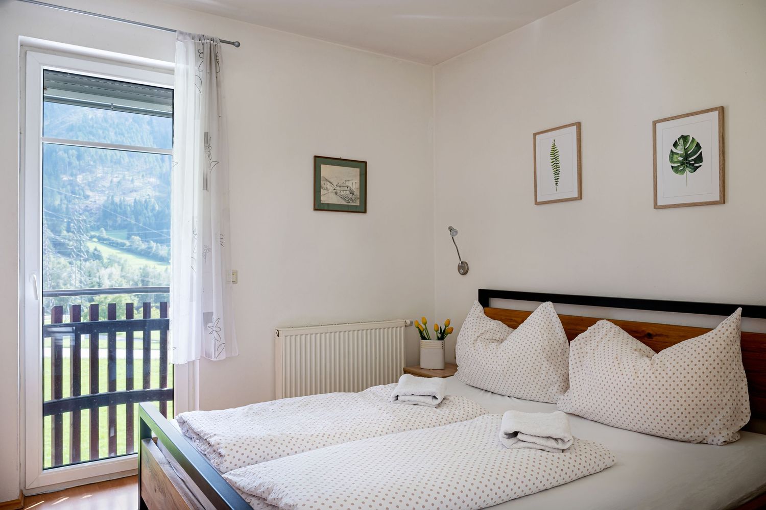 Klidná ložnice v horském stylu. Pohodlná manželské postel pro relaxaci. Interiérová fotografie apartmánu v horách.