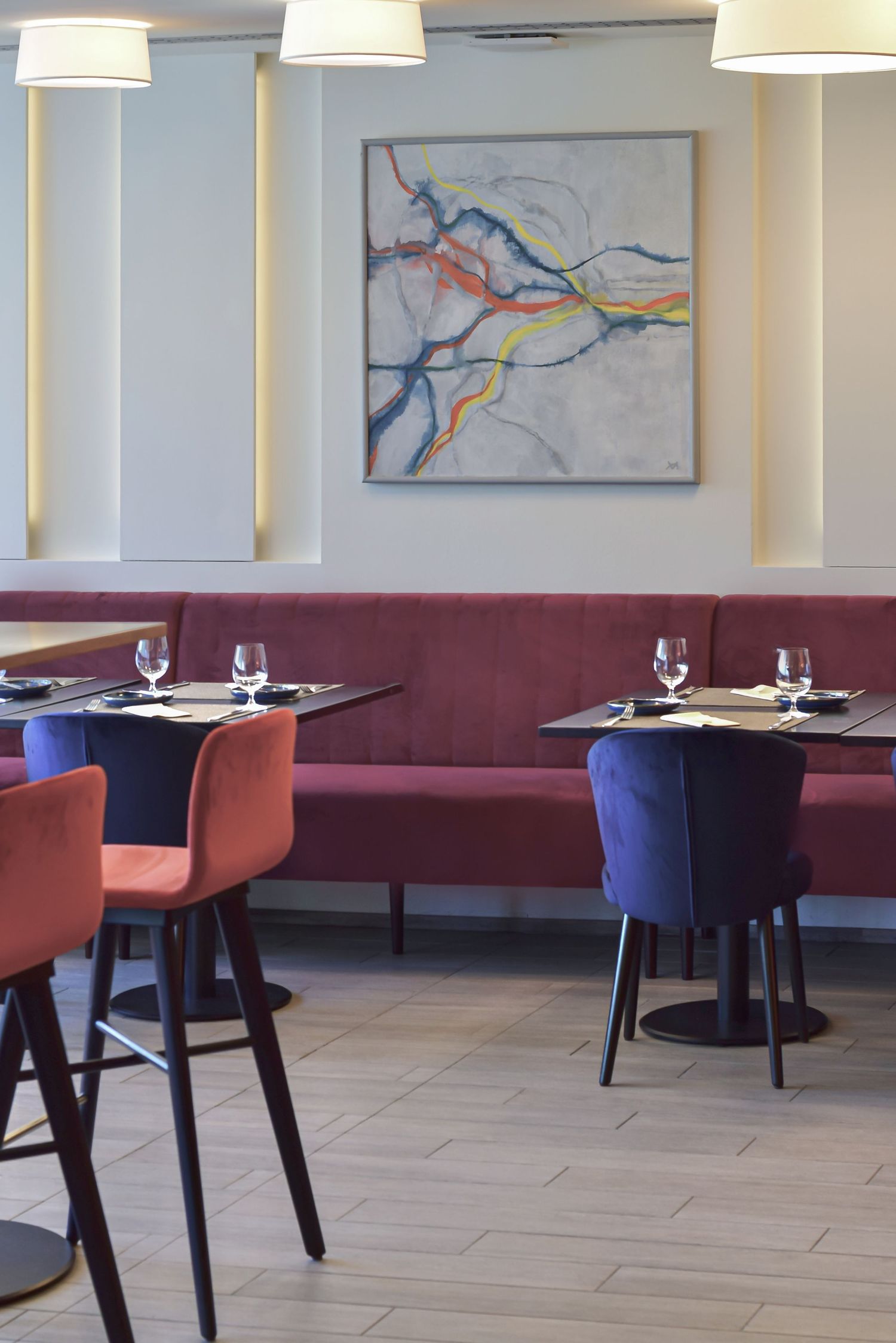 Interiér moderní restaurace. Stoly připravené k obědu. Stylové osvětlení a designový nábytek. Focení komerčních interiérů.