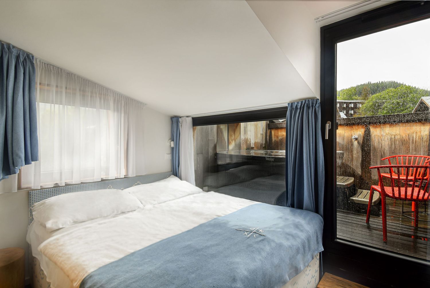 Ložnice s přímým vstupem na terasu s vlastní vířivkou. Luxusní ubytování pro páry s wellness v Krkonoších. Fotografie interiéru.