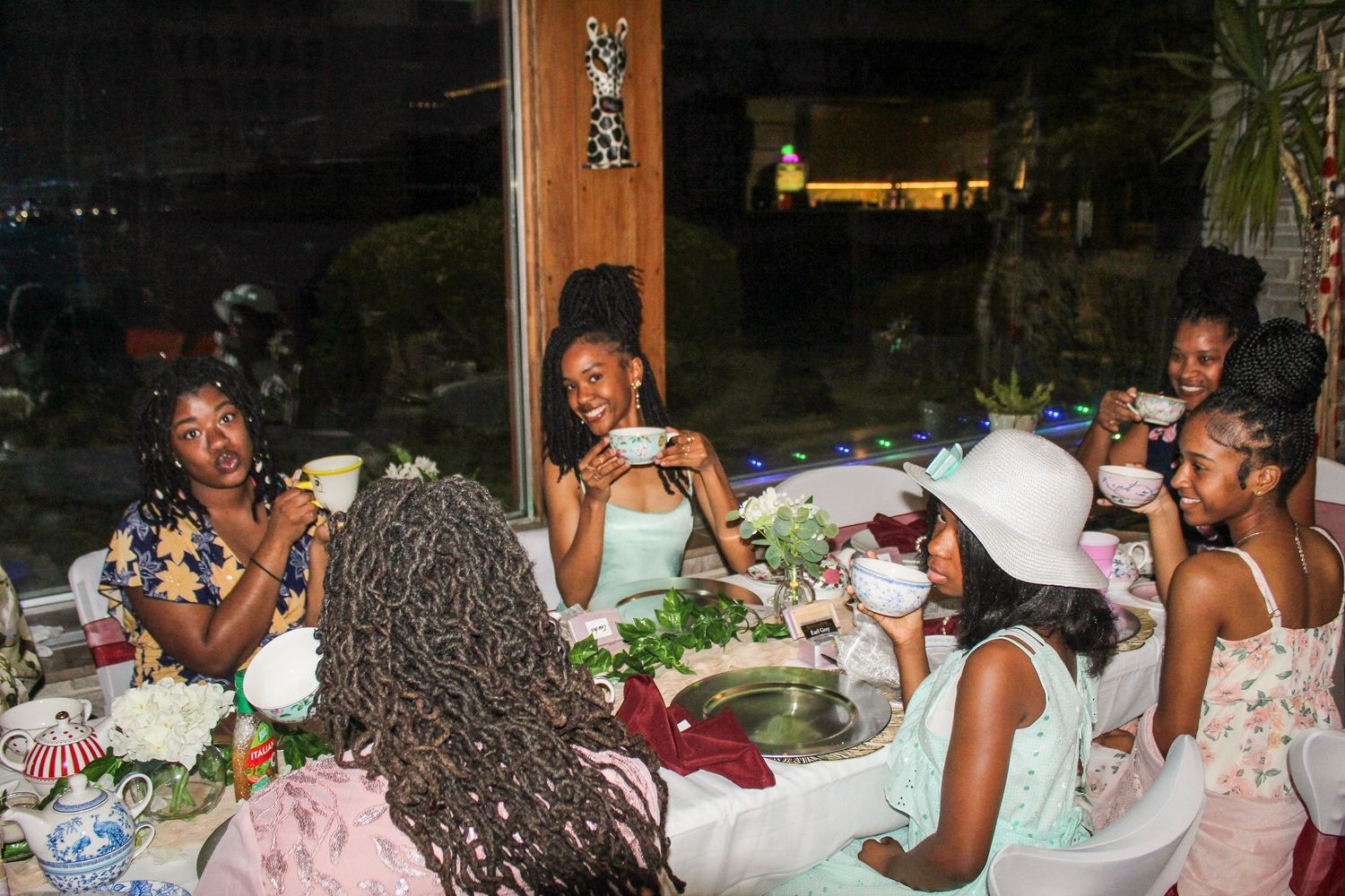 People enjoying dinner and conversation at elegantly set tables during an evening gathering.
