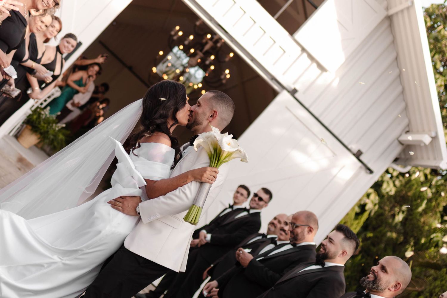Wedding guests enjoying festivities inside decorated reception tent.