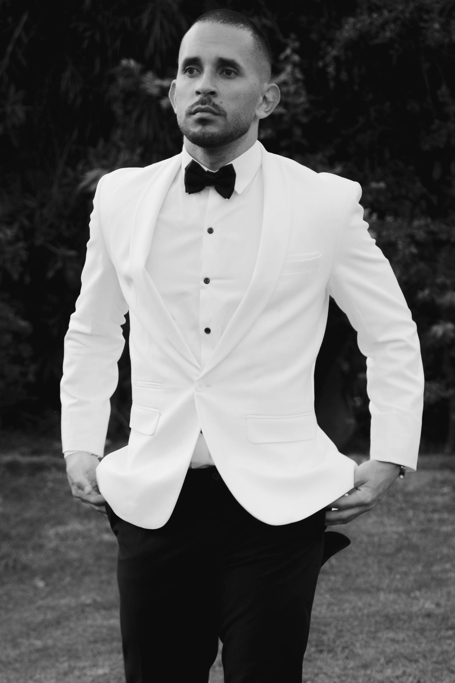 A stylish white tuxedo jacket paired with black trousers and bow tie creates an elegant formal look.