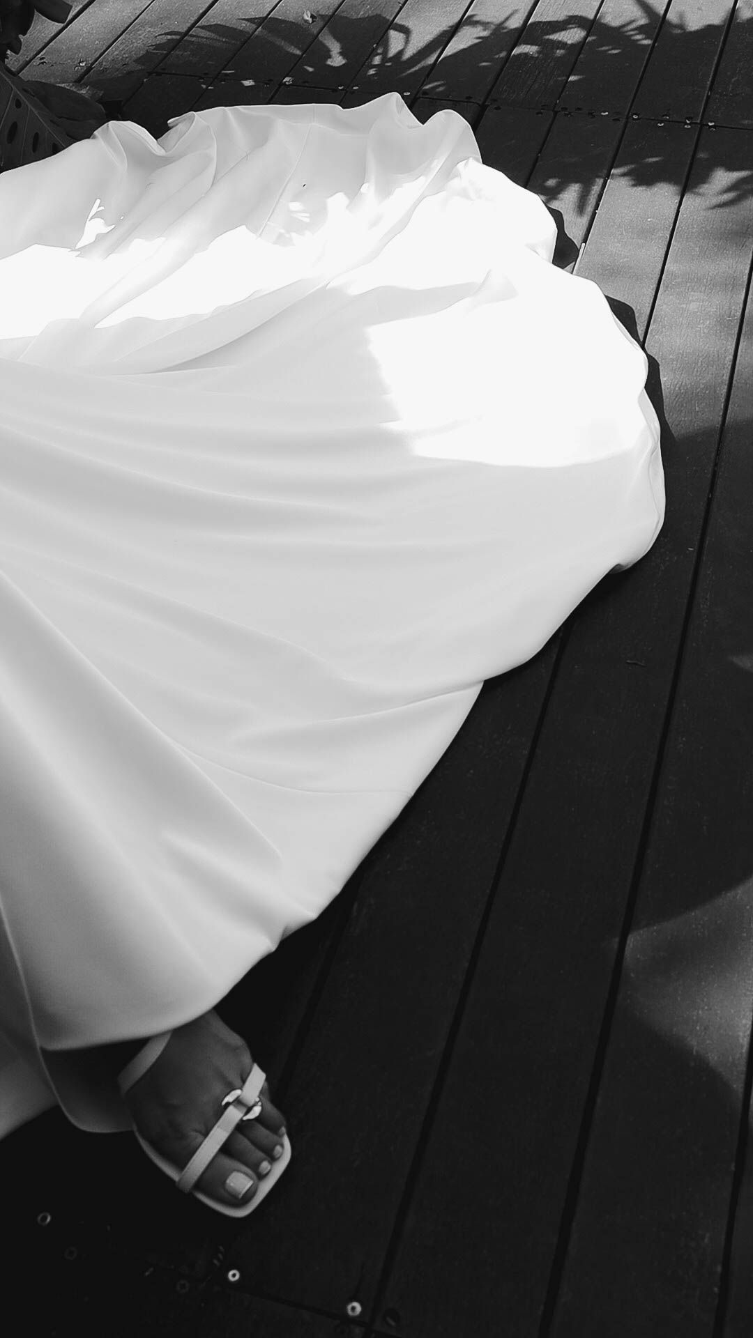 Flowing white wedding dress captured in dramatic black and white sequence.
