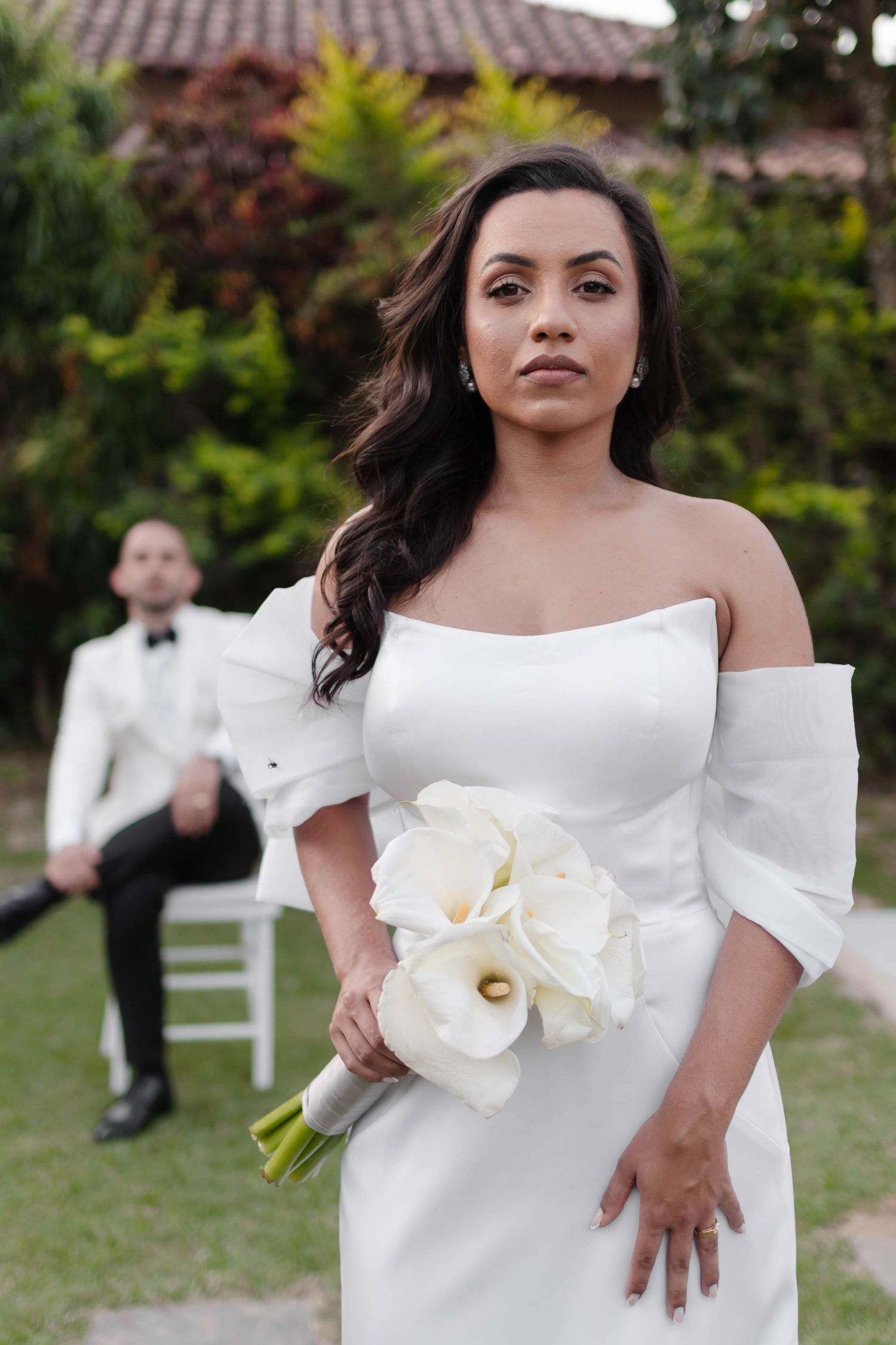 Elegant bridal portrait in garden setting with white orchid details.