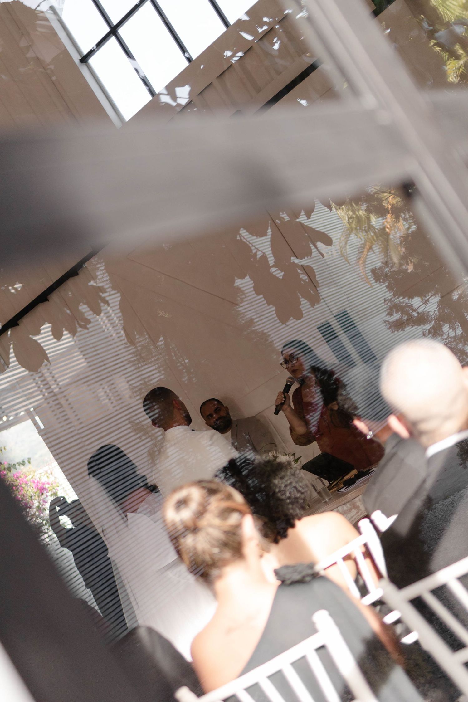 Silhouettes of people gathering by a window with sunlight streaming through creating dramatic shadows.