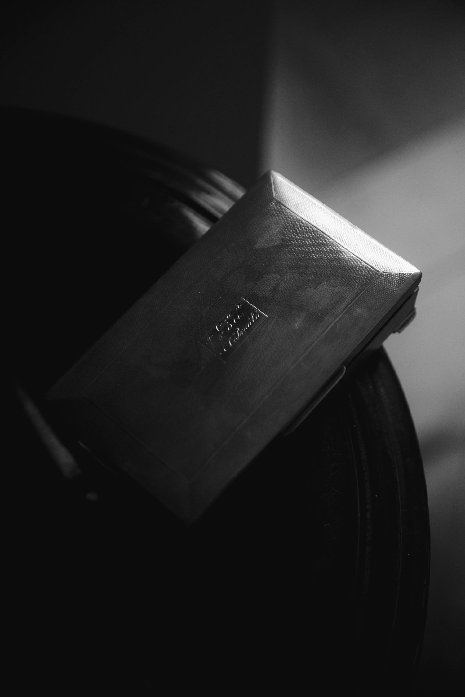 Minimalist black and white close-up photograph of a book spine with dramatic lighting and shadows.
