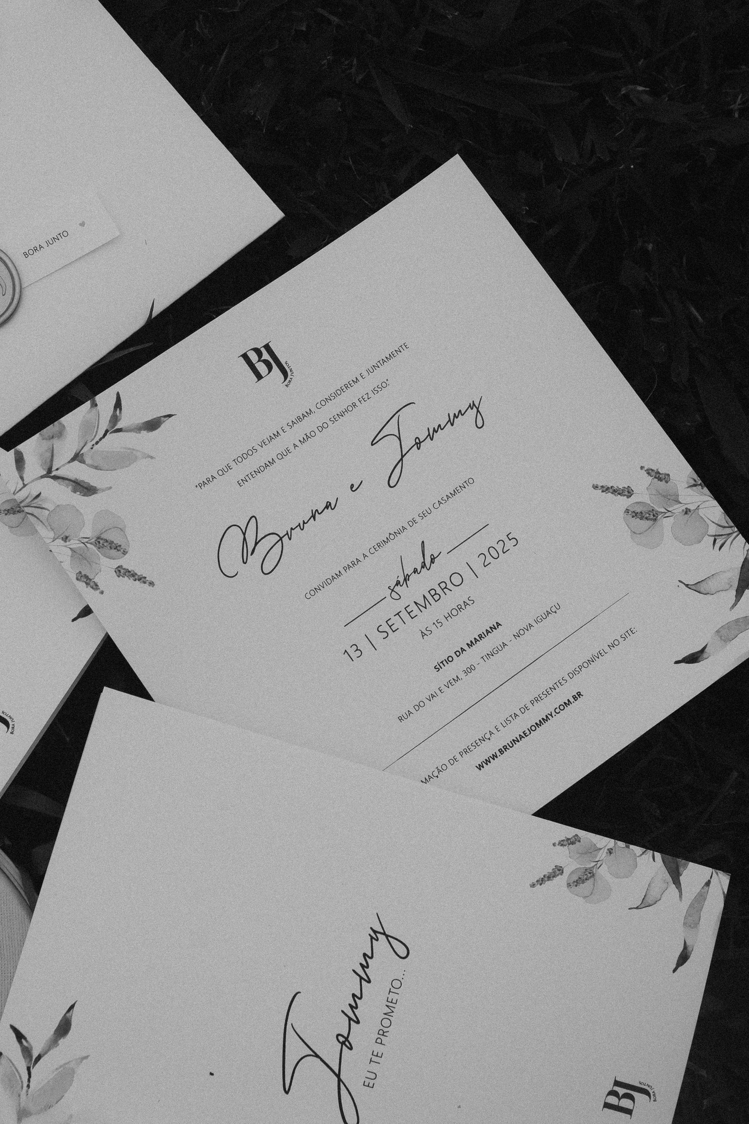 Wedding invitation cards with elegant floral designs arranged on dark background.