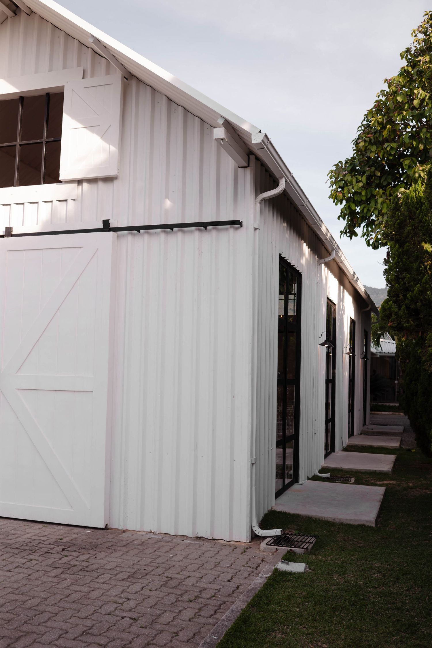 A series of connected white architectural structures with modern design elements form a walkway or corridor.