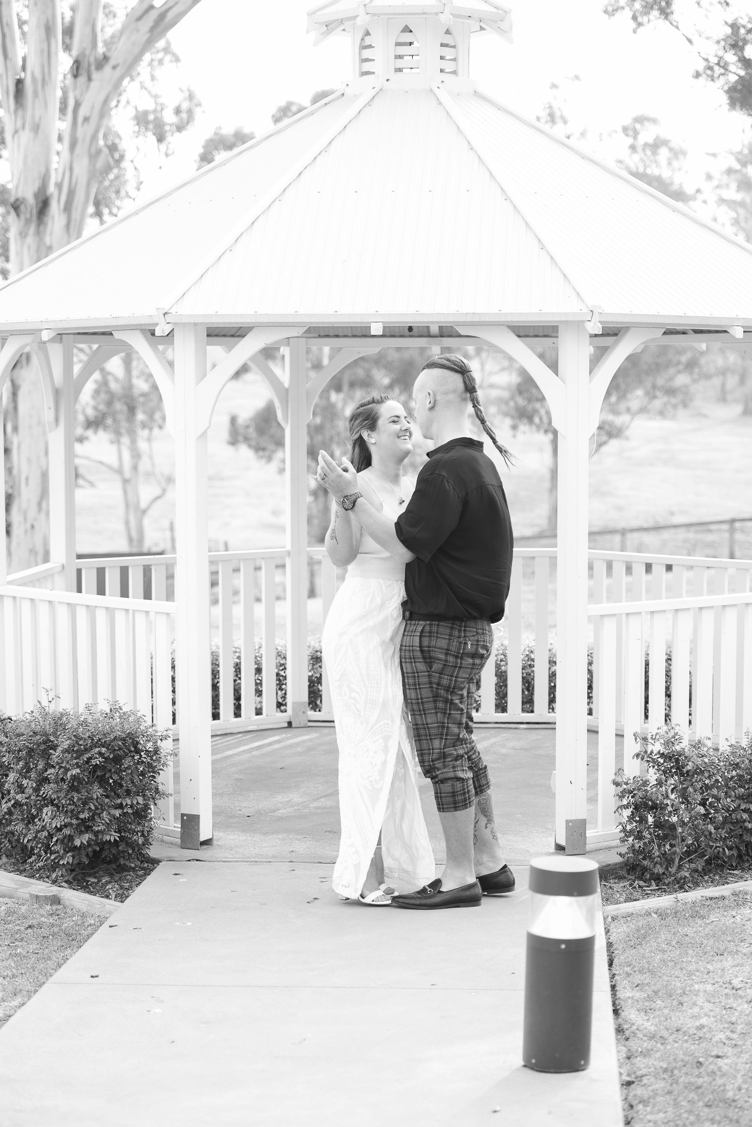 A sequence of black and white photos showing the Bride and Groom dancing together in a gazebo.