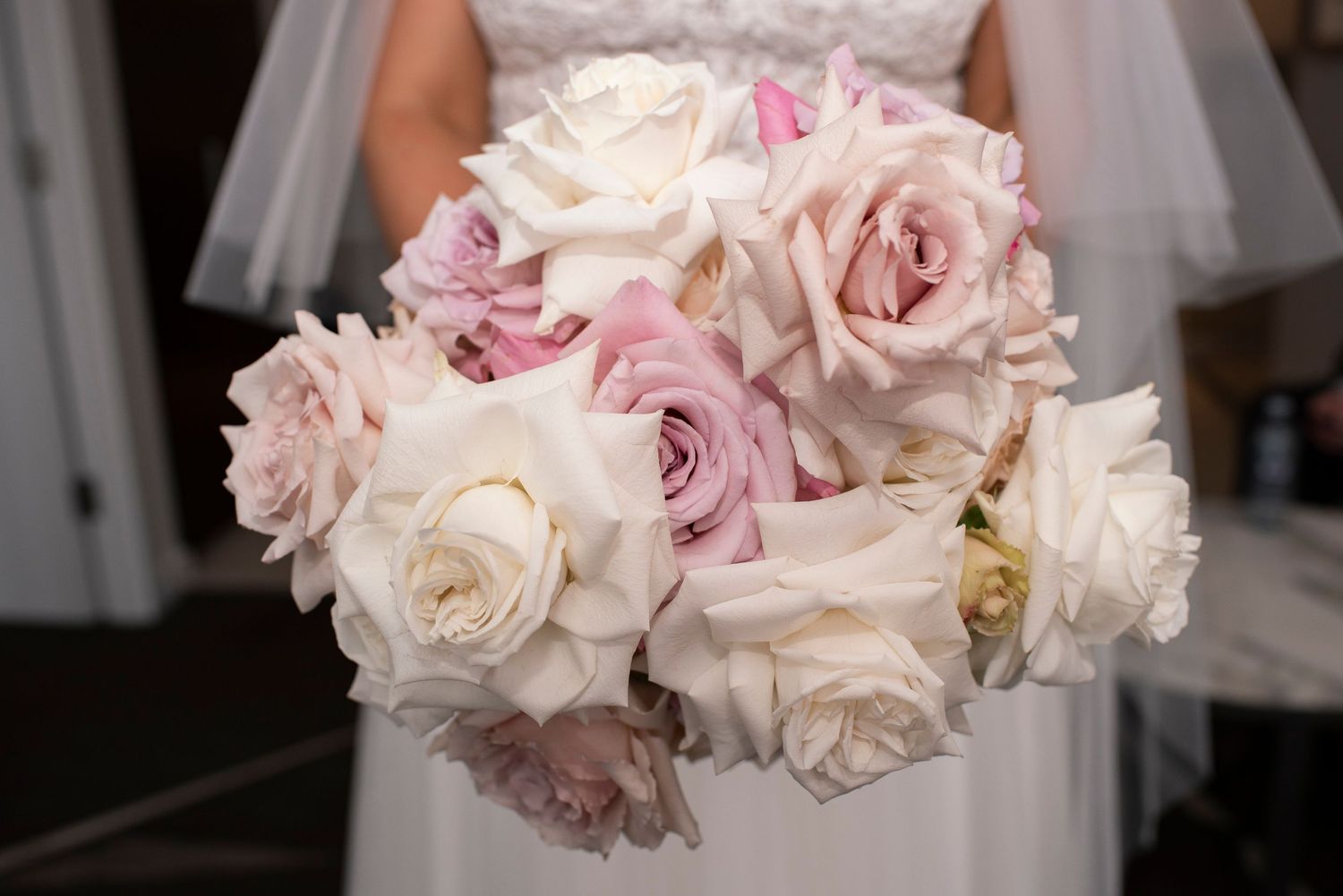 Delicate pink and white rose bouquet with lace detail.