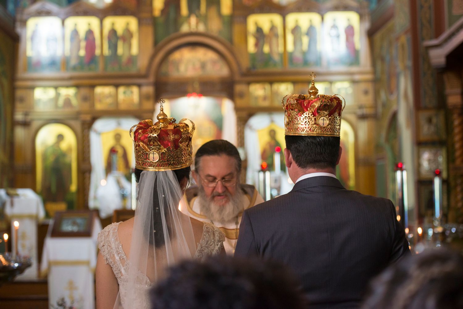 Orthodox wedding ceremony taking place inside a traditional church with gilded icons and decorative elements.