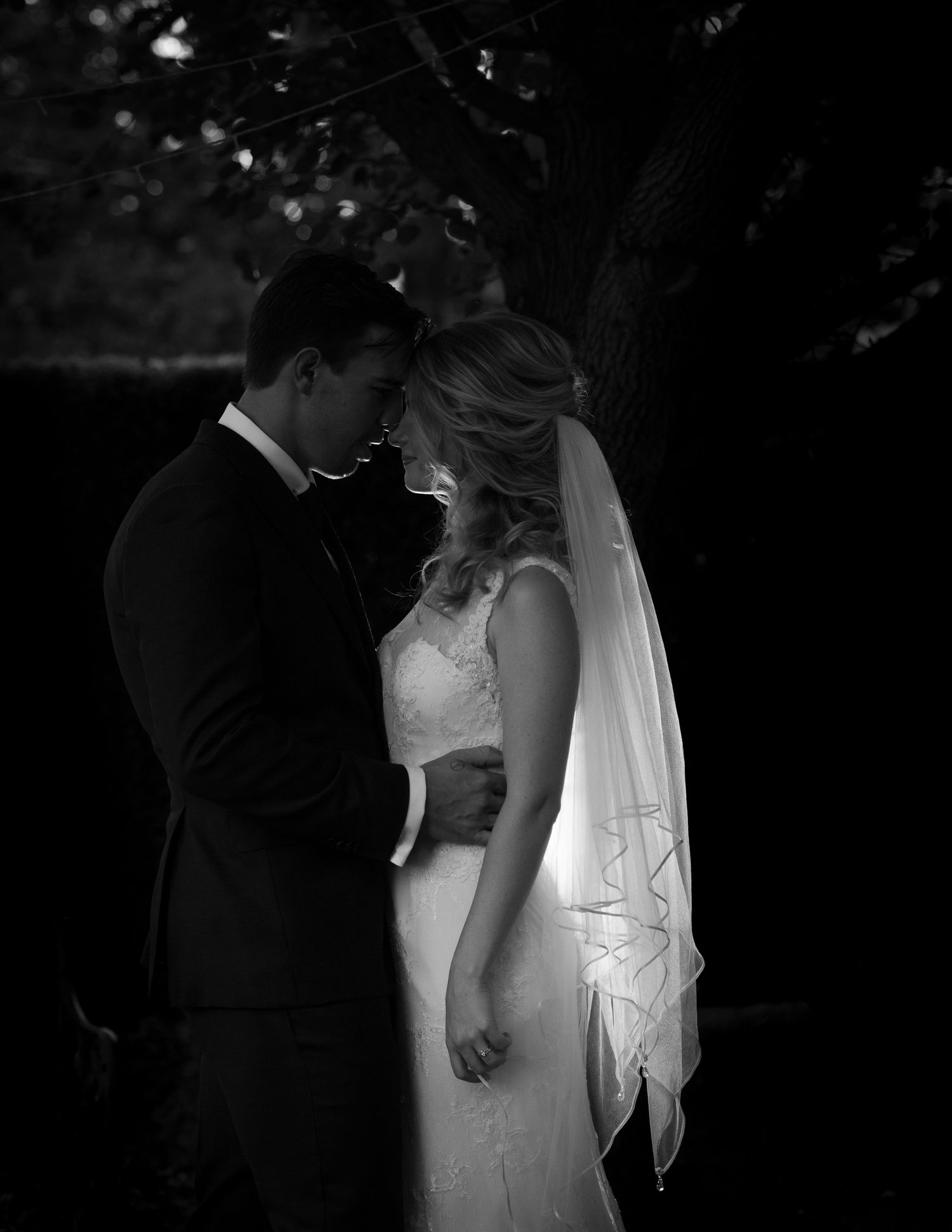A romantic black and white photo series showing intimate moments between a couple on their wedding day.