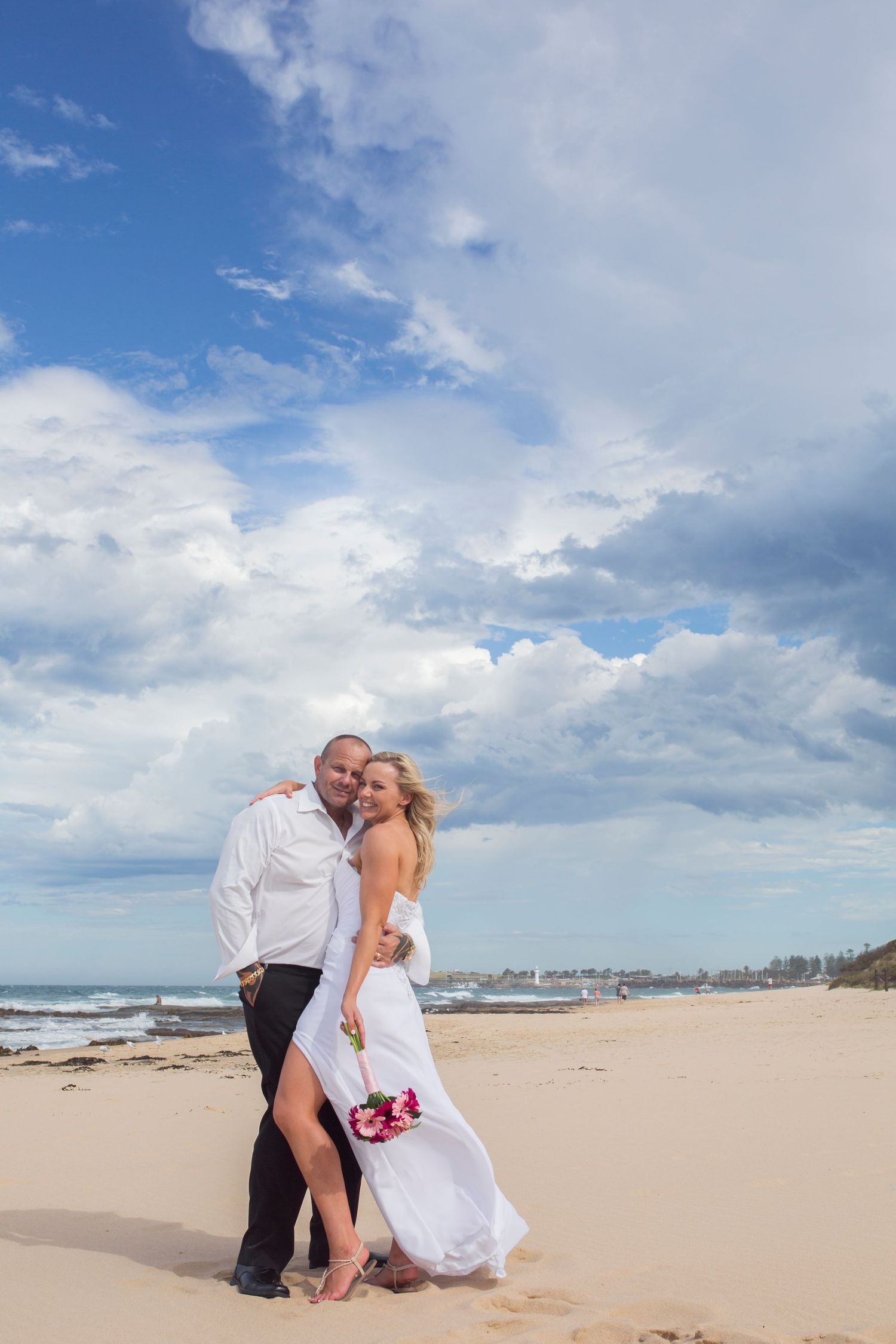 Romantic beach photoshoot series showing bride and groom posing along sandy coastline with ocean views in Wollongong.
