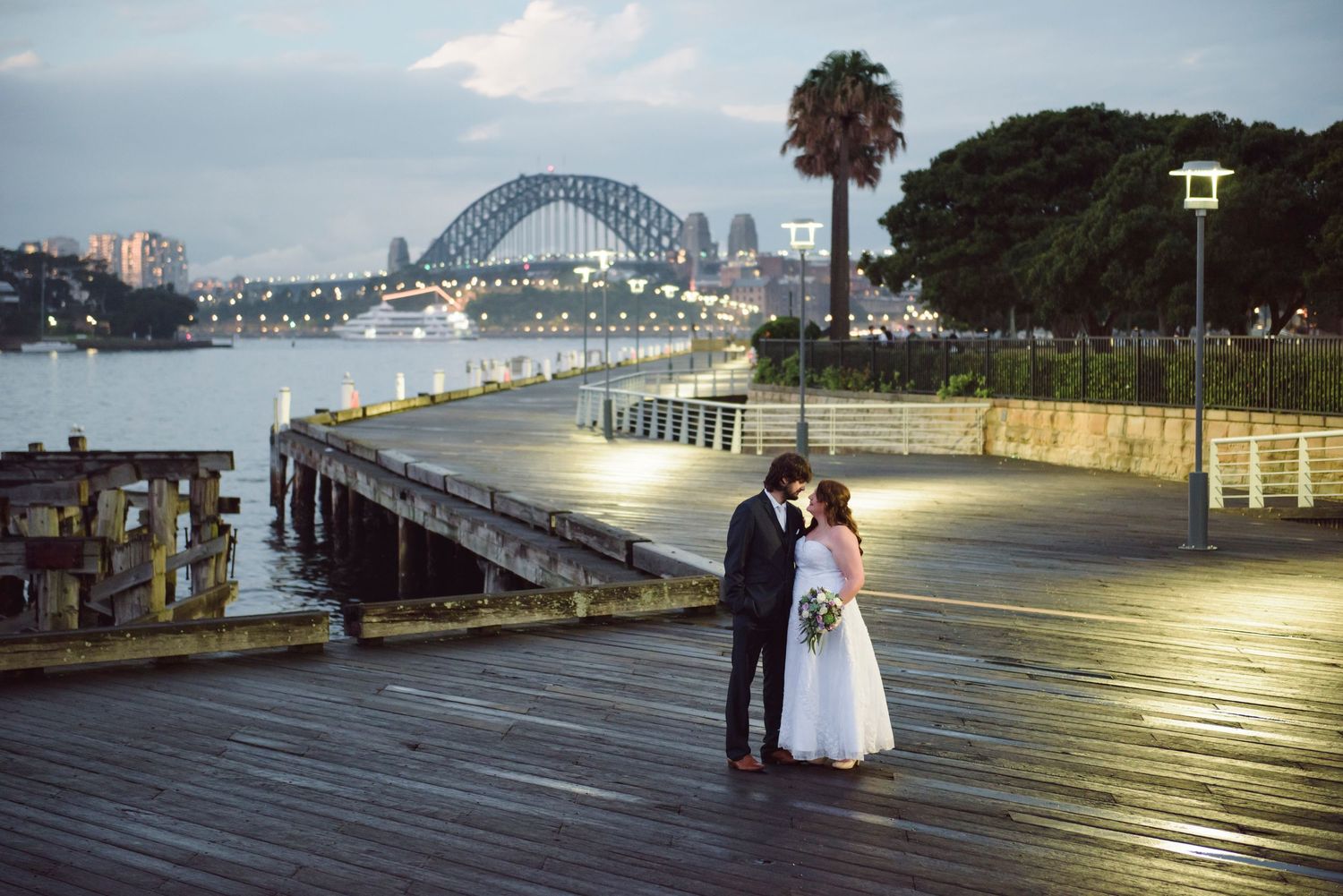 Bride and groom during night portraits with Sydney Harbour Bridge in background.