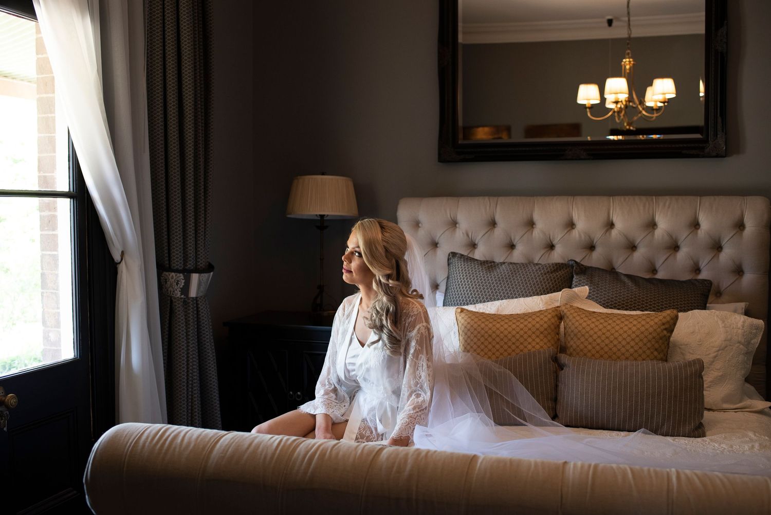 A luxurious bedroom interior with tufted headboard, plush bedding, and warm ambient lighting creates an elegant atmosphere.
