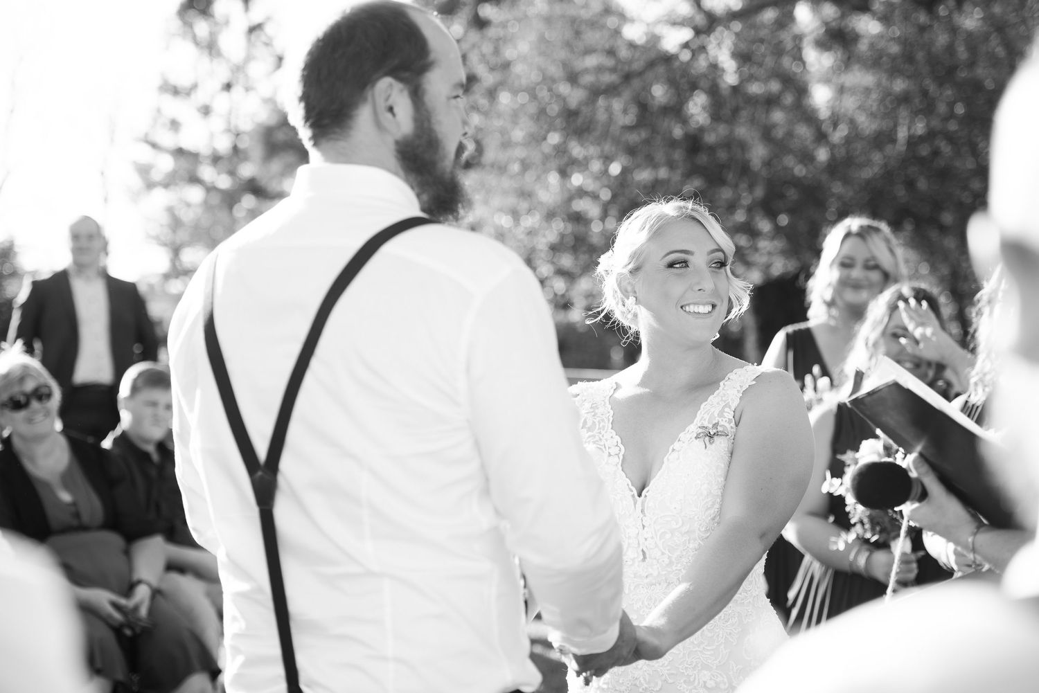 A collage of black and white wedding photos showing couple during an outdoor ceremony.