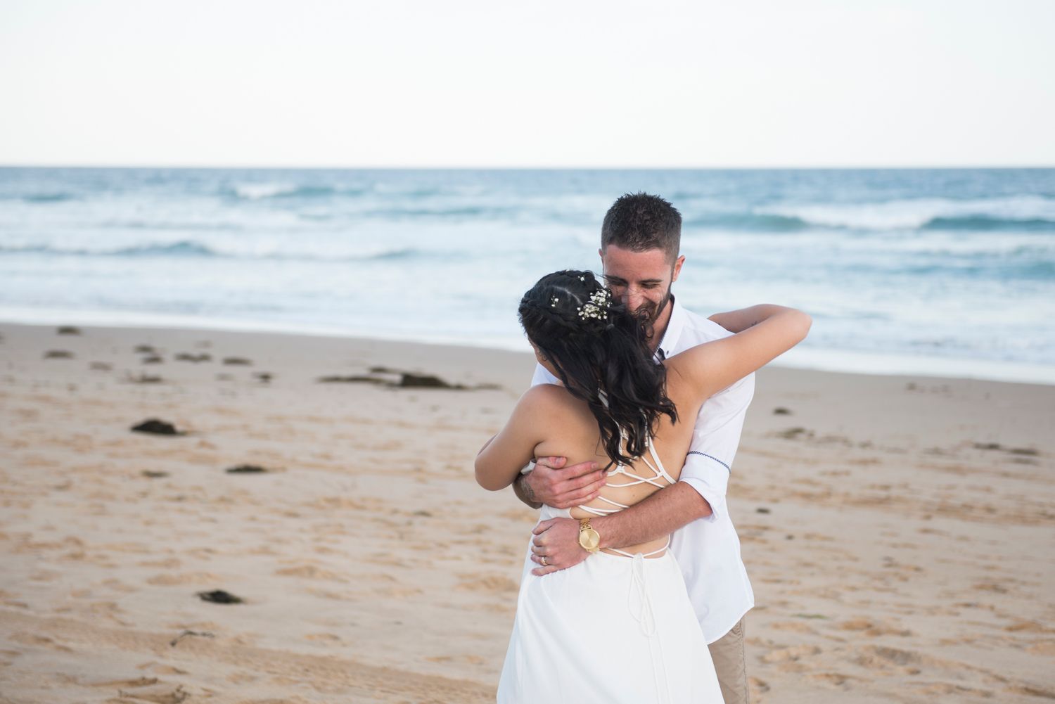 Romantic beach wedding photography sequence showing playful moments between newlyweds.