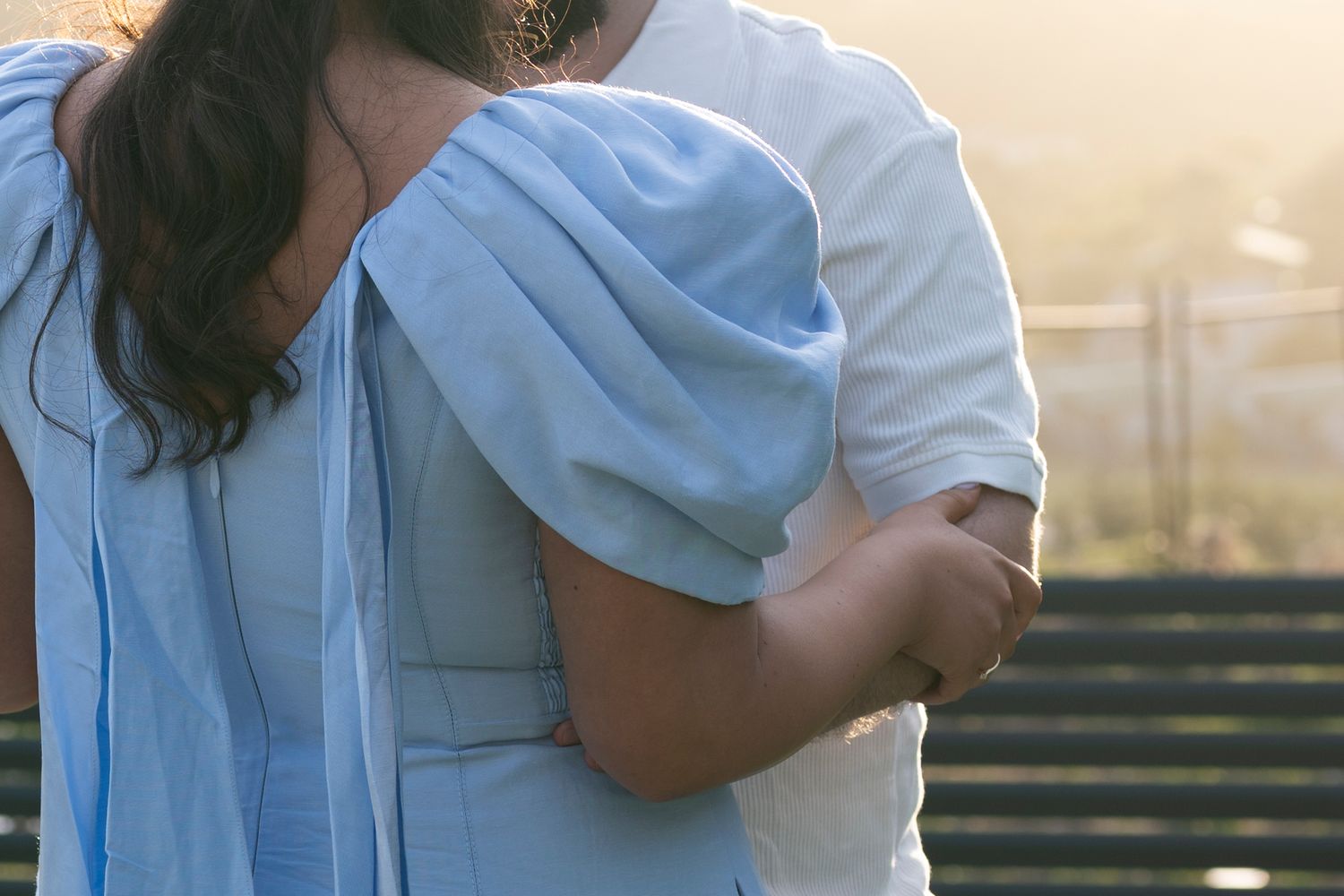 A couple embraces on a sunny day.