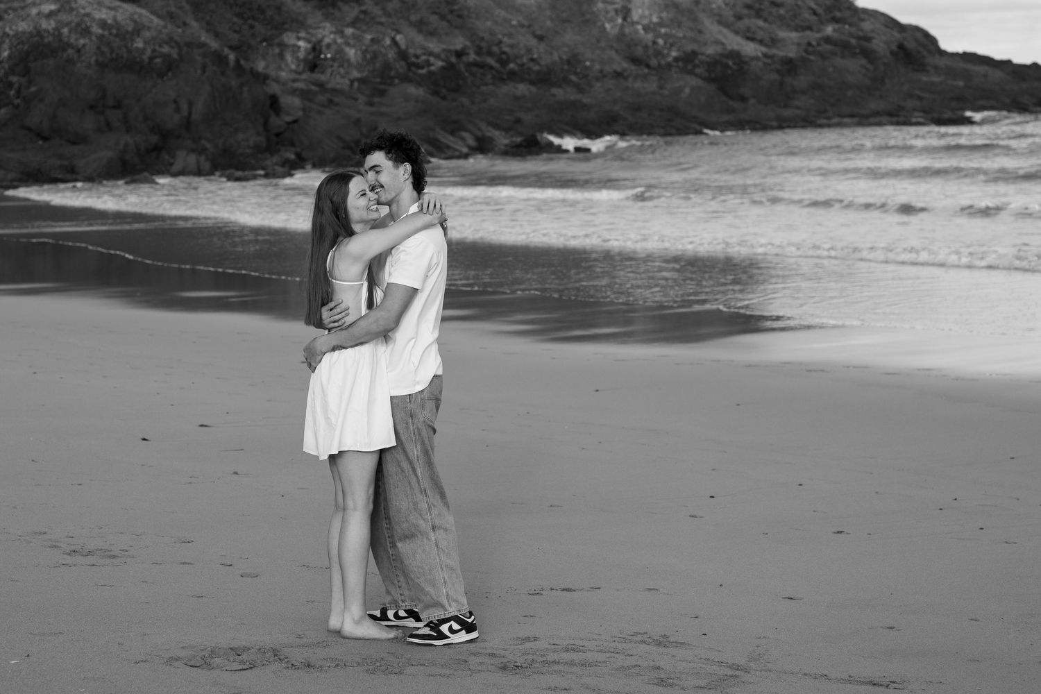 Coastal photography session with dramatic rocky cliffs and ocean waves.