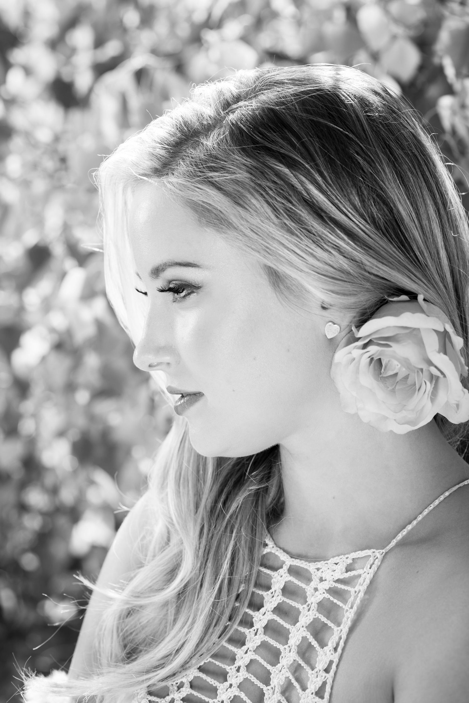 Black and white portrait with delicate lace detail and flower hair accessory.