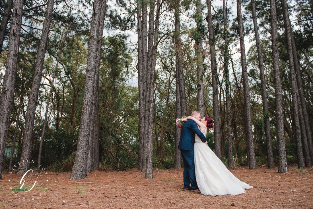 Pine forest wedding venue with tall trees and natural lighting.