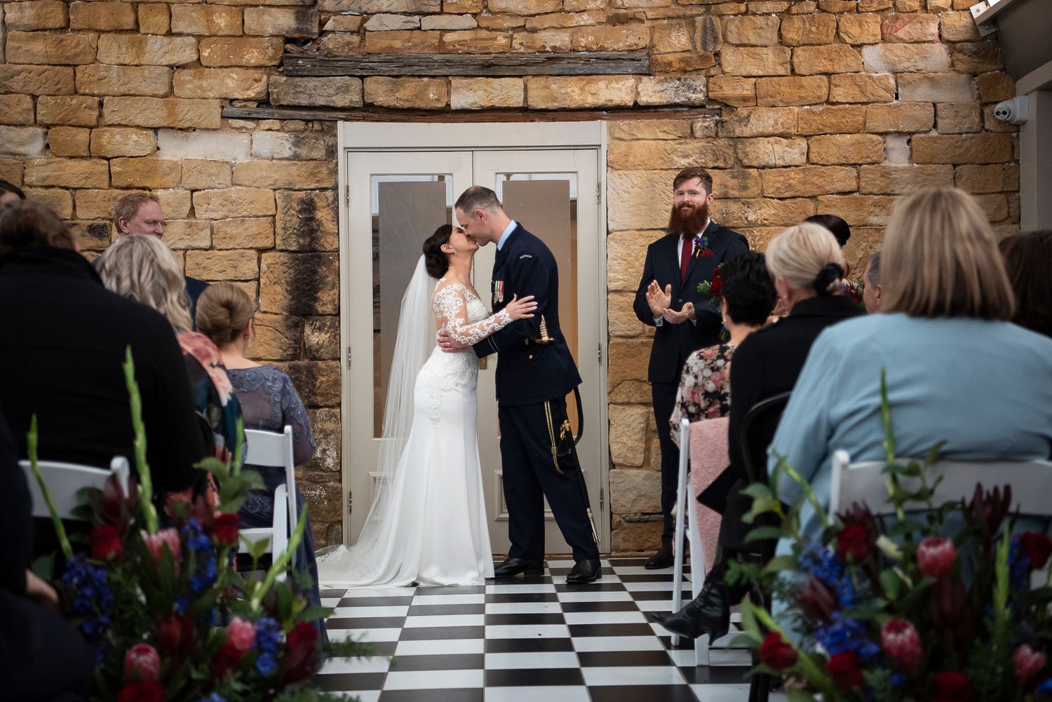 Elegant wedding ceremony setup against a rustic stone wall backdrop.