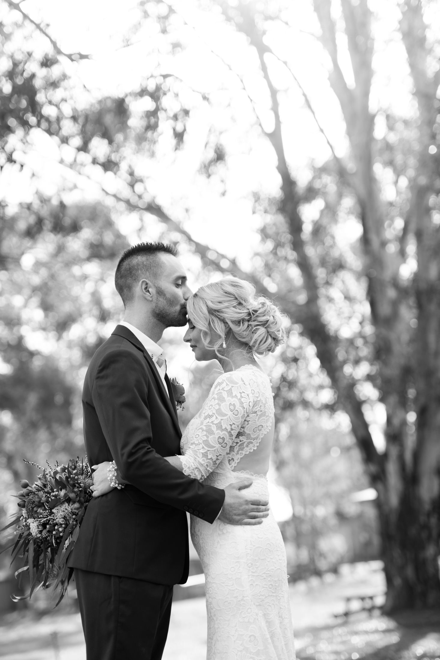 A romantic black and white wedding photo sequence showing a couple sharing tender moments in a wooded outdoor setting.