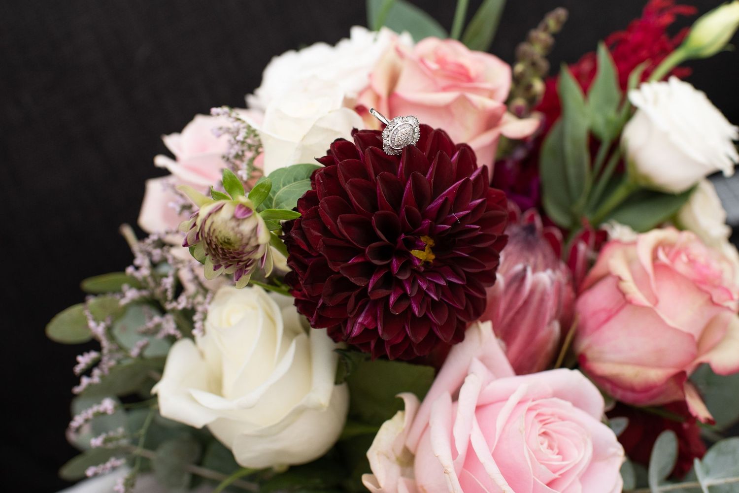 Close-up view of pink and burgundy floral with roses and dahlias.