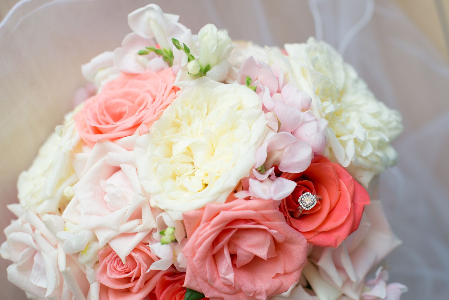 Elegant floral arrangements featuring coral and blush roses with white accents.