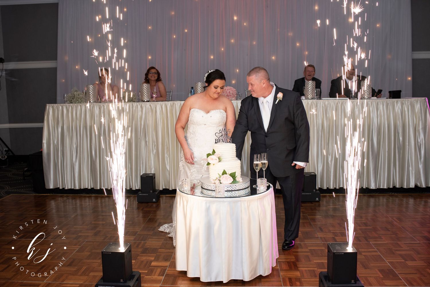 Couple sharing their first dance at a wedding reception with sparkler fountains creating a magical atmosphere.