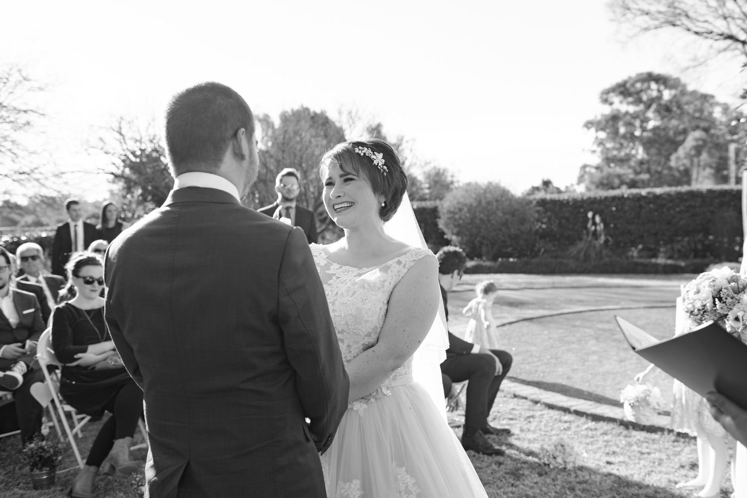 Couple during vows at wedding ceremony in black and white.